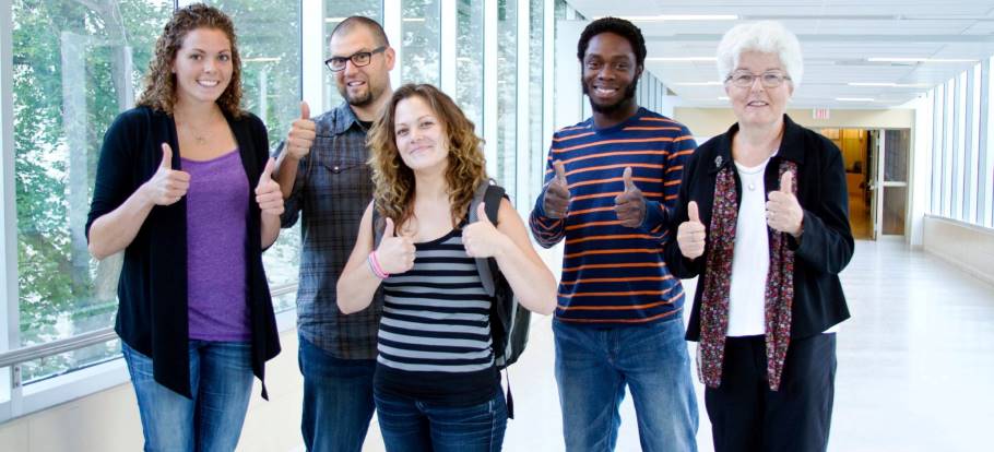 Image of a teacher with teachers - with their thumbs up